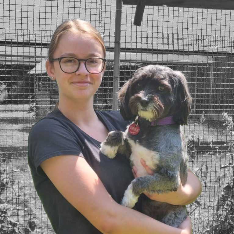 Lilly Sorgalla Junge Frau hält einen kleinen Hund in den Armen, beide lächeln in die Kamera.