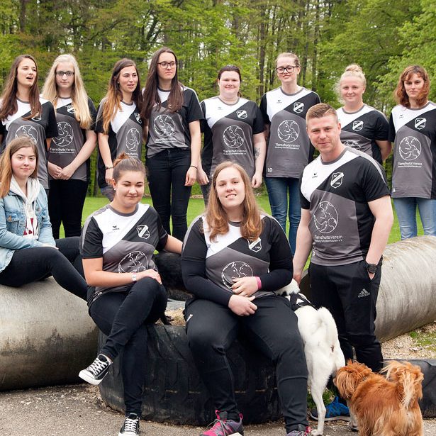 SV Scheppach Damen Gruppe von Menschen in sportlicher Kleidung, umgeben von Bäumen und Hunden.