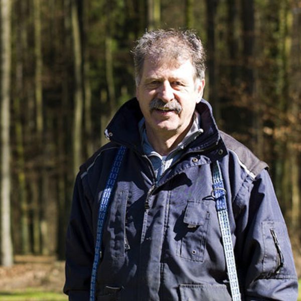 Gerd Schmidt Mann in einem Wald, trägt eine Jacke und steht im Freien.